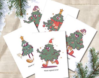 May include: A set of five white greeting cards featuring cartoon Christmas tree characters with arms, legs, and faces. The trees wear hats, scarves, and ornaments. One card displays the text Have a good one! in black lettering.