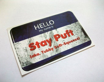 May include: A blue and white name tag with the text "HELLO my name is Stay Puff (aka. Tubby Soft-Squeeze)"