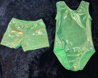 May include: A green leotard and matching shorts with a shimmery finish. The leotard has a scoop neck and sleeveless design. The shorts are a pull-on style.