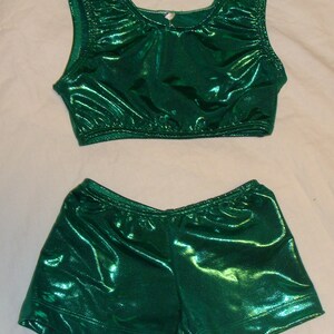 May include: A green shiny leotard with a matching pair of shorts. The leotard has a scoop neck and sleeveless design. The shorts are a high-waisted style.