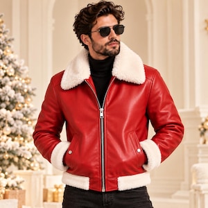 May include: A vibrant red leather jacket featuring a thick white faux-shearling collar, cuffs, and hem. The jacket has a central silver metal zipper closure and two front pockets with silver snap buttons, worn over a black turtleneck sweater.