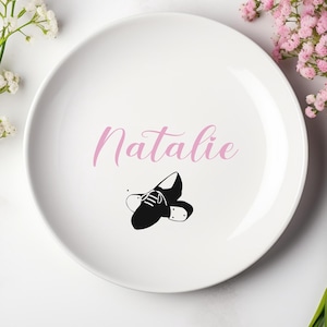May include: White ceramic plate with the name "Natalie" written in pink script. A black and white illustration of a pair of tap shoes is below the name.