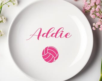 May include: White ceramic plate with the name "Addie" written in pink cursive script and a pink volleyball graphic.