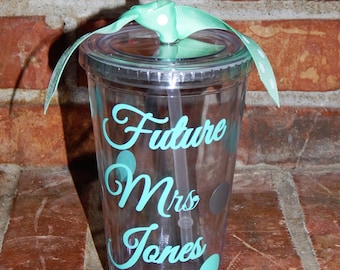 May include: A clear plastic tumbler with a turquoise lid and a turquoise and white polka dot ribbon. The tumbler has a turquoise vinyl decal that says "Future Mrs. Jones".