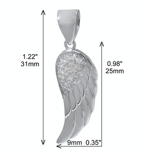 May include: Silver angel wing pendant with clear cubic zirconia stones. The wing measures 1.22 inches tall, 0.98 inches wide, and 0.35 inches thick.