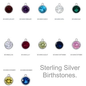 May include: Sterling silver birthstone charms for each month of the year. The charms are small and round, with a silver bail. Each charm features a different colored gemstone, representing the birthstone for that month.