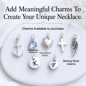 May include: A collection of seven sterling silver charms including an anchor, a light blue birthstone, a heart, a cross, a wing, and two round and heart-shaped discs engraved with the initials K and F. Text reads: Add Meaningful Charms To Create Your Unique Necklace.