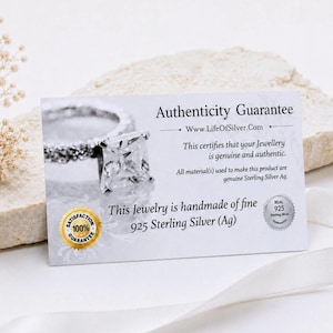 May include: A white rectangular authenticity guarantee card featuring a silver ring image and text stating Authenticity Guarantee, Www.LifeOfSilver.Com, This certifies that your Jewellery is genuine and authentic, and This Jewelry is handmade of fine 925 Sterling Silver (Ag) with a gold 100% satisfaction seal.