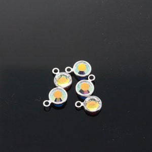 May include: Five silver-toned connector charms with iridescent rainbow-coloured glass stones. Each charm has a loop on the top and a small loop on the side.