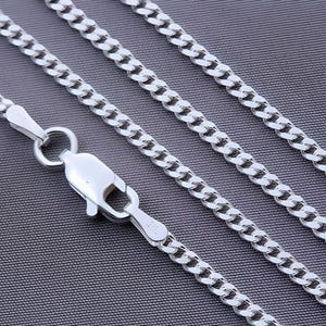 Puede incluir: Un collar de cadena curb plateado con cierre de langosta. La cadena se muestra en tres longitudes diferentes.