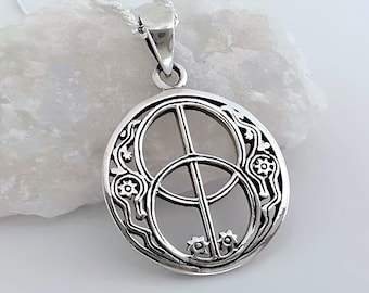 May include: A circular silver pendant featuring an openwork design with two overlapping circles and a vertical line, accented by small floral motifs along the edges. The pendant hangs from a delicate silver chain, showcasing a polished metallic finish.
