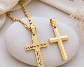 May include: Two gold-toned cross pendants, one attached to a matching curb chain. The left cross is engraved with the text "Baptized in Christ" and the date "04.05.2024". Both pendants feature a smooth, polished finish and a simple, clean design.