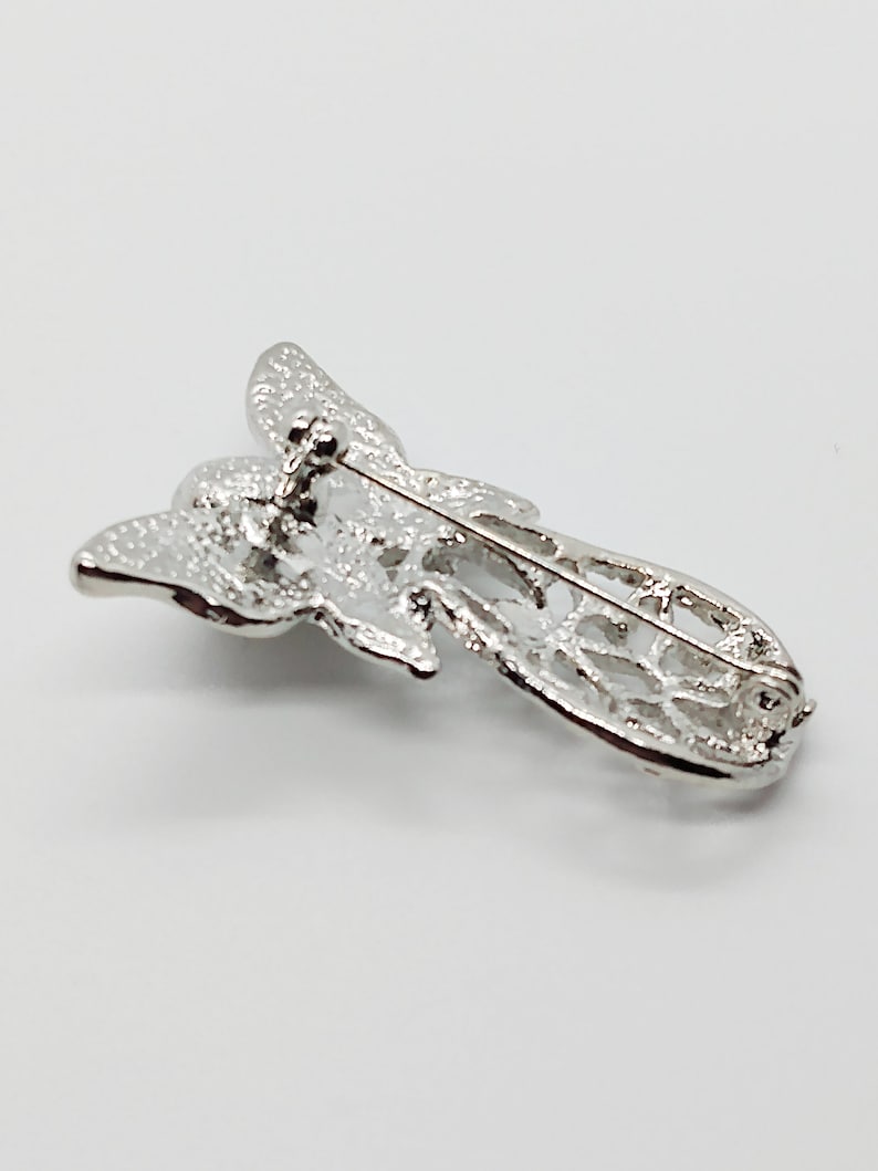 Vintage angel brooch pin with swirly pattern /& butterfly wings silver tone metal with white faux pearl ; about 1 12 x 1 in.