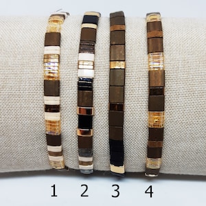 May include: Four brown and gold bracelets with different patterns. The bracelets are numbered 1 through 4.