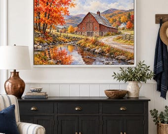 May include: A framed landscape painting depicting a red barn situated beside a flowing stream, surrounded by vibrant autumn foliage in shades of orange and yellow, with rolling mountains visible in the distant background under a cloudy sky.