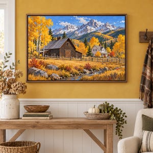 May include: A framed landscape painting depicting a rustic wooden barn and a white house nestled in a valley with golden autumn trees, a flowing stream, and snow-capped mountain peaks under a bright blue sky with scattered white clouds.