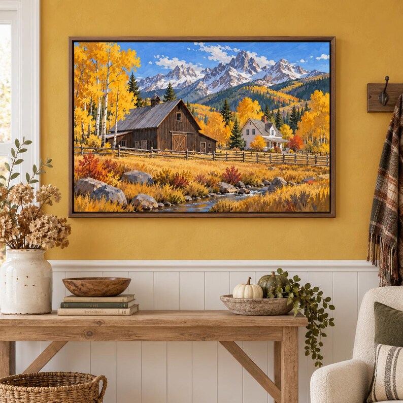 May include: A framed landscape painting depicting a rustic wooden barn and a white house nestled in a valley with golden autumn trees, a flowing stream, and snow-capped mountain peaks under a bright blue sky with scattered white clouds.