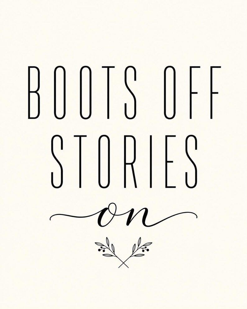 May include: A white wall art print featuring the black text BOOTS OFF STORIES ON in a combination of tall sans-serif and elegant cursive script fonts, accented by a small botanical illustration of two crossed leafy branches.