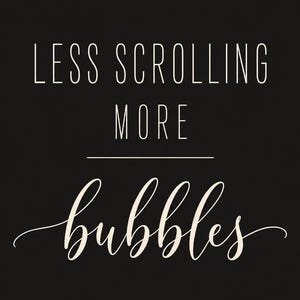 May include: A black rectangular sign featuring the white text LESS SCROLLING MORE in a clean sans-serif font, followed by a horizontal line and the word bubbles written in a white, elegant, flowing cursive script font.