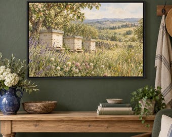 May include: A framed landscape painting depicting three wooden beehives situated in a lush meadow filled with lavender and clover, set against a backdrop of rolling hills, trees, and a soft sky, all enclosed in a simple black frame.