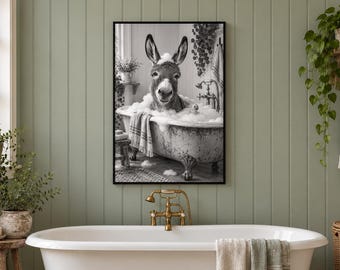 May include: A black and white framed wall art print depicting a donkey sitting in a clawfoot bathtub filled with soap bubbles. The donkey has foam on its head and ears, and a striped towel hangs over the side of the tub in the scene.