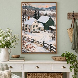 May include: A framed landscape painting depicting a winter scene with a cream-colored house and a dark green barn covered in snow. A wooden fence lines a snow-covered path leading toward the buildings under a soft sunset sky with trees.