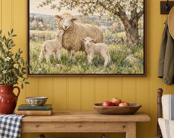 May include: A framed wall art print depicting a large sheep standing in a grassy field with two small lambs under a blooming tree. The scene features rolling hills in the background, soft natural lighting, and a pastoral landscape setting.