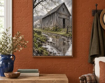 May include: A framed wall art print depicting a weathered wooden barn situated beside a muddy path with a reflective puddle. The scene features a cloudy sky, bare tree branches, and a stone foundation under the structure, rendered in muted tones.