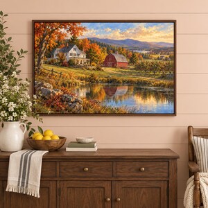 May include: A rectangular wall art print depicting a landscape with a white house and a red barn near a pond, surrounded by autumn trees and mountains under a sunset sky. The scene features warm orange and yellow foliage reflected in the water.