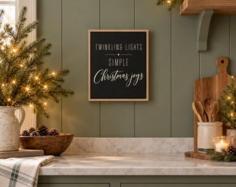 Puede incluir: Un letrero de pared rectangular con marco de madera clara y fondo negro. El texto en blanco dice TWINKLING LIGHTS, un pequeño símbolo de estrella, SIMPLE y Christmas joys en letra cursiva. El letrero está montado en una pared verde.