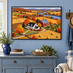 May include: A framed landscape painting depicting a rural scene with a white house, a red barn, golden hay fields, and a winding blue river under a clear sky. The artwork features vibrant autumn foliage in shades of orange, yellow, and red.