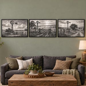 May include: A set of three black and white landscape wall art prints featuring rural scenes with windmills, wooden fences, and dirt paths, each enclosed in a thin black frame and displayed horizontally in a row on a wall.