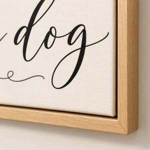May include: A rectangular canvas wall art piece featuring black cursive text that includes the word dog, set against a cream-colored background. The canvas is encased in a light-toned wooden frame with a clean, simple edge profile.