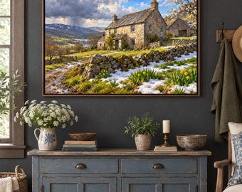 May include: A framed landscape wall art print depicting a stone cottage in a rural setting with a stone wall, patches of snow, and yellow daffodils in the foreground, set against a backdrop of rolling hills and a stormy sky.