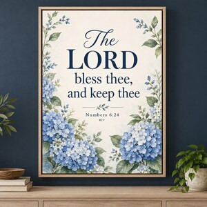 Puede incluir: Una impresi&oacute;n de arte mural enmarcada con el texto The LORD bless thee, and keep thee, Numbers 6:24 KJV, rodeada de ilustraciones en acuarela de flores de hortensia azules y blancas y hojas verdes sobre un fondo color crema.