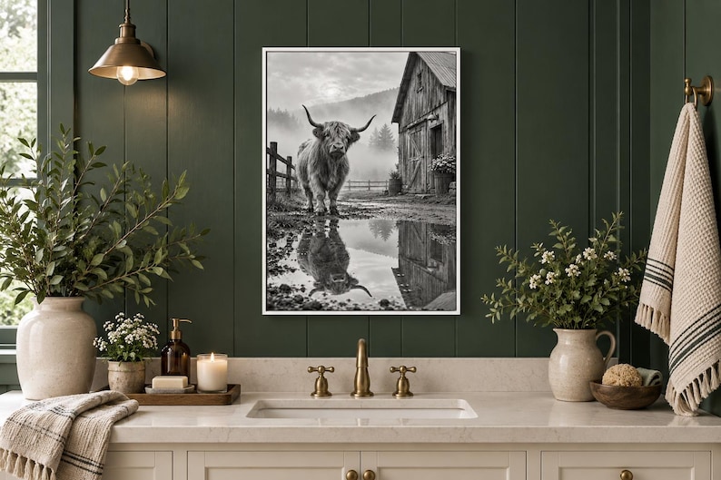 Puede incluir: Una impresi&oacute;n de arte mural en blanco y negro enmarcada que muestra una vaca Highland de pie en un campo embarrado cerca de un granero de madera r&uacute;stico. La escena incluye un charco en primer plano que refleja la vaca y el granero.