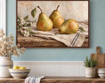 May include: A framed rectangular wall art print depicting three ripe green and yellow pears resting on a textured beige linen cloth atop a weathered wooden surface, accompanied by a small sprig of white pear blossoms with green leaves.