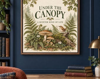 May include: A square framed wall art print featuring a forest scene with ferns, mushrooms, and a small bird perched on a log. The text reads Under the Canopy A Quieter Kind of Life. The illustration uses earthy tones of green, brown, and cream.