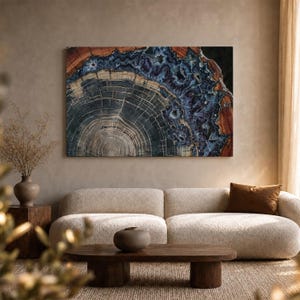 May include: A rectangular wall art print featuring a cross-section of a petrified wood log. The centre displays concentric grey and white growth rings, surrounded by a vibrant, crystalline border of deep blue, indigo, and rust-coloured mineral deposits.