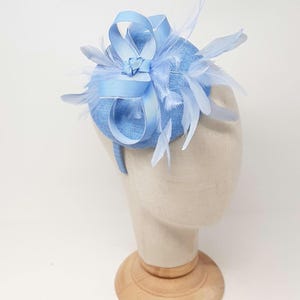 Cornflower blue percher style button fasinator with feathers.