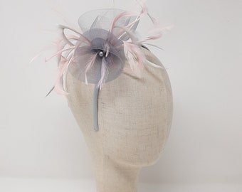 Silver grey fascinator with accent colour of pale pink. With a clip, comb and Alice band