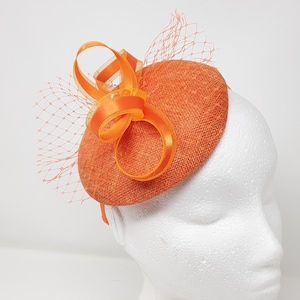 Orange percher style button fasinator with netting.