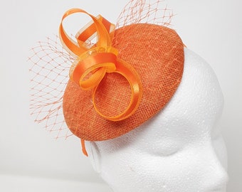 Orange percher style button fasinator with netting.