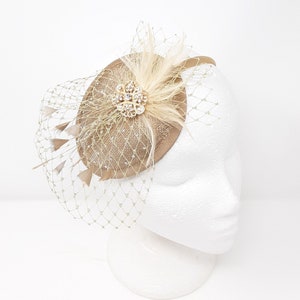 Shimmering gold teardrop shape fascinator with rhinestone brooch.