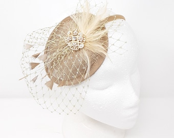 Shimmering gold teardrop shape fascinator with rhinestone brooch.