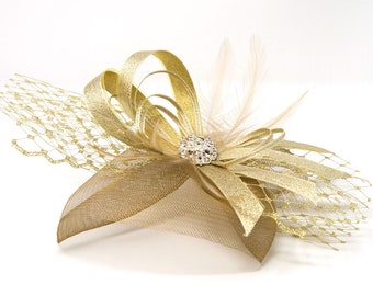 Fascinator oro metallizzato con spilla diamantè su clip, pettine e fascia Alice.