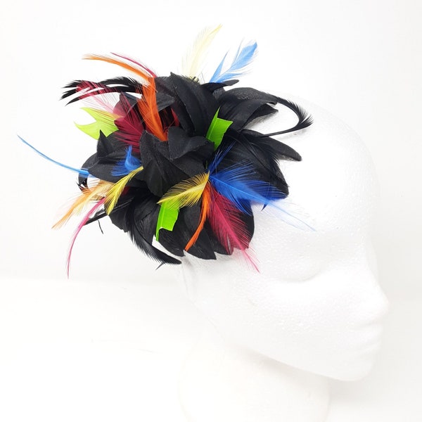 Corsage en épingle à cheveux avec fleur noire et plumes multicolores.