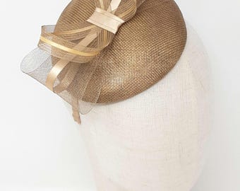 Fascinator percher à bouton or métallique avec noeud en filet, coiffe d'invité de mariage chic.