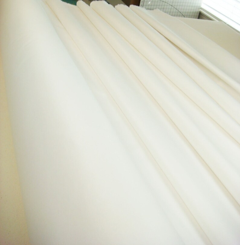 May include: A close-up of a white fabric, folded in a series of parallel lines, creating a smooth, even surface.