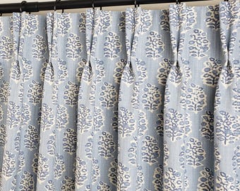 May include: Blue curtains with a white and blue floral pattern. The curtains are pleated and have a rod pocket.